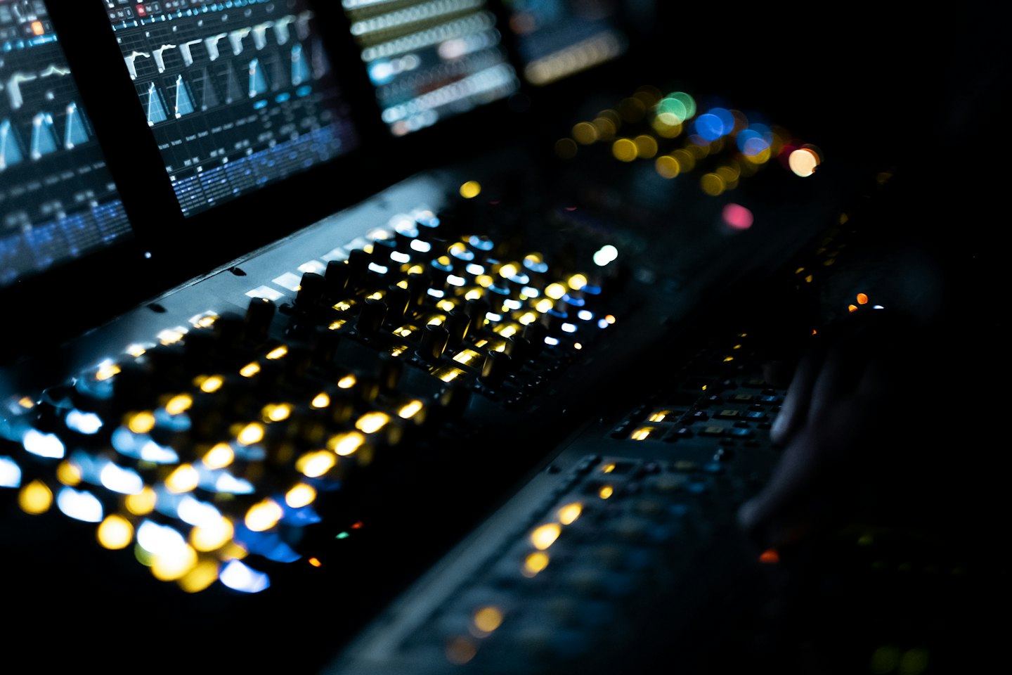 Mixing console with glowing buttons and faders.
